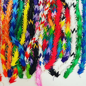 multi colored origami cranes stringed together.