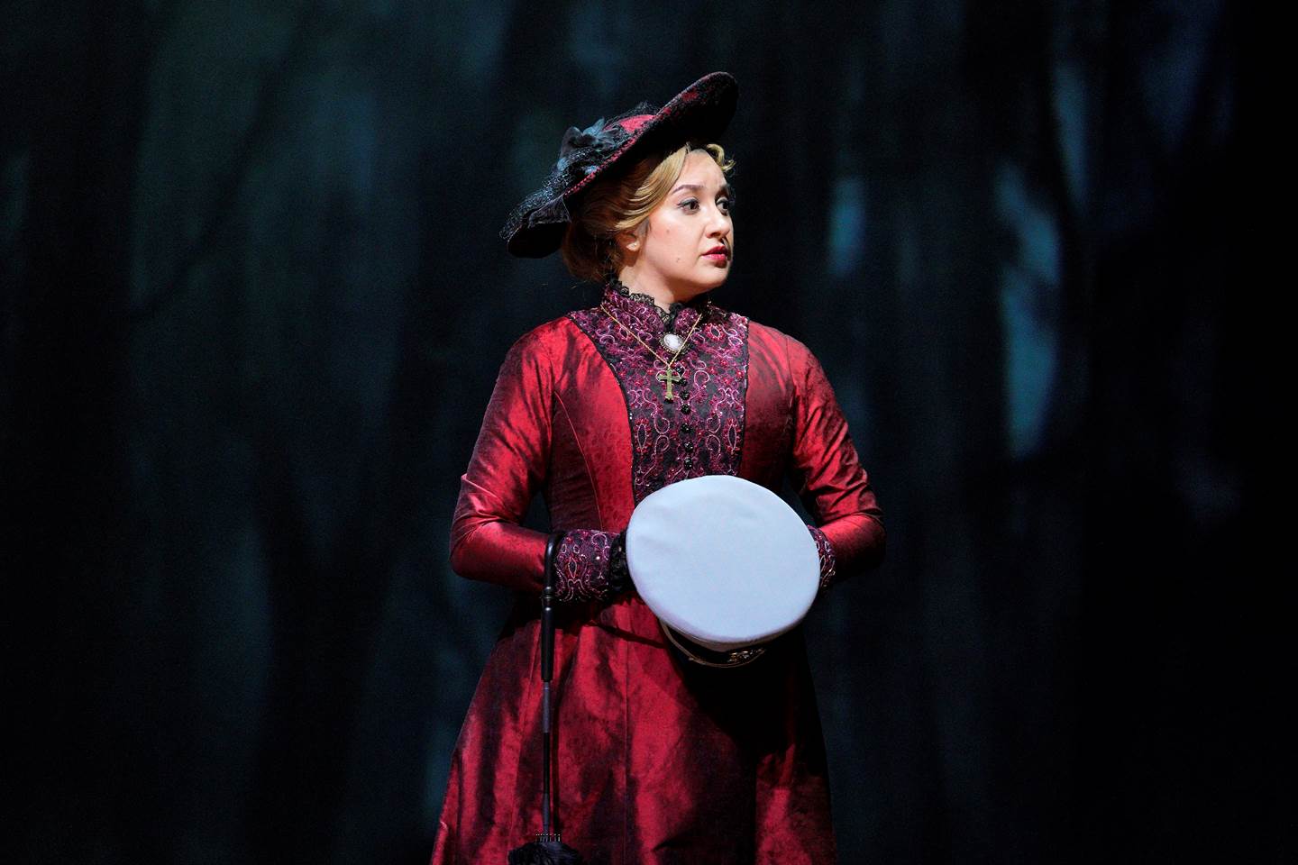 Woman in red dress holding a white sailors hat