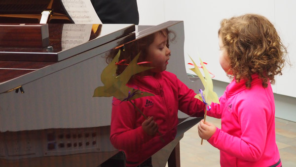 First Act Little Princess. Child holding paper bird next to a piano