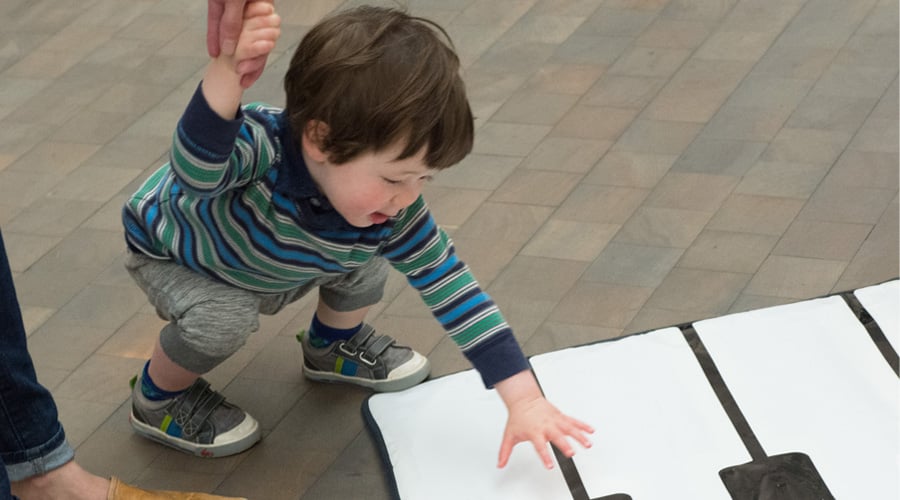 Child playing with piano play mat