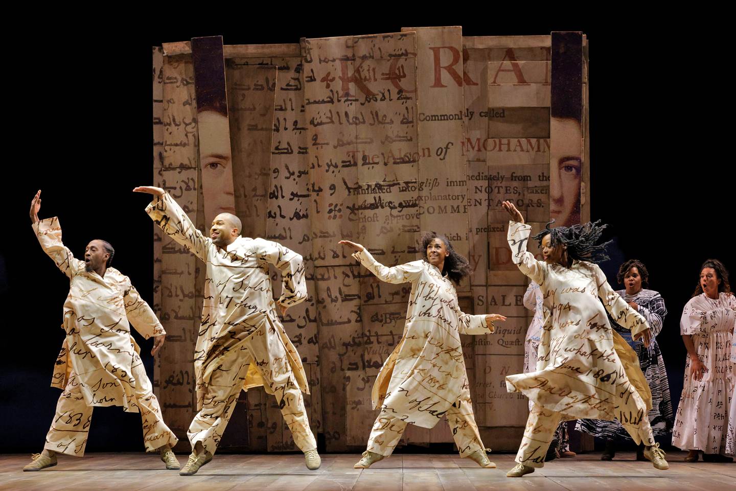 people dancing on stage wearing lettered clothing