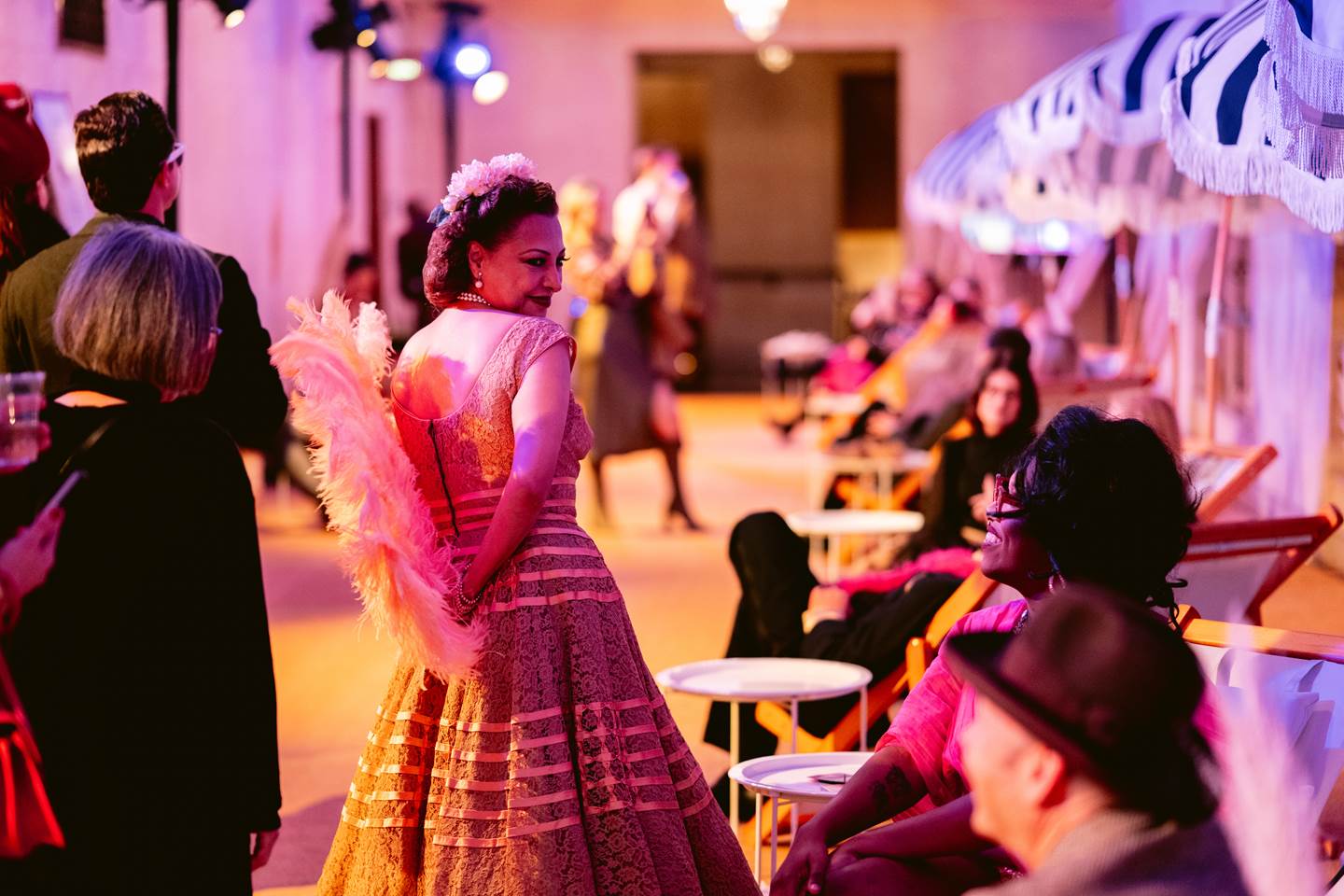 Opera performer walking through crowd conversing with patrons.