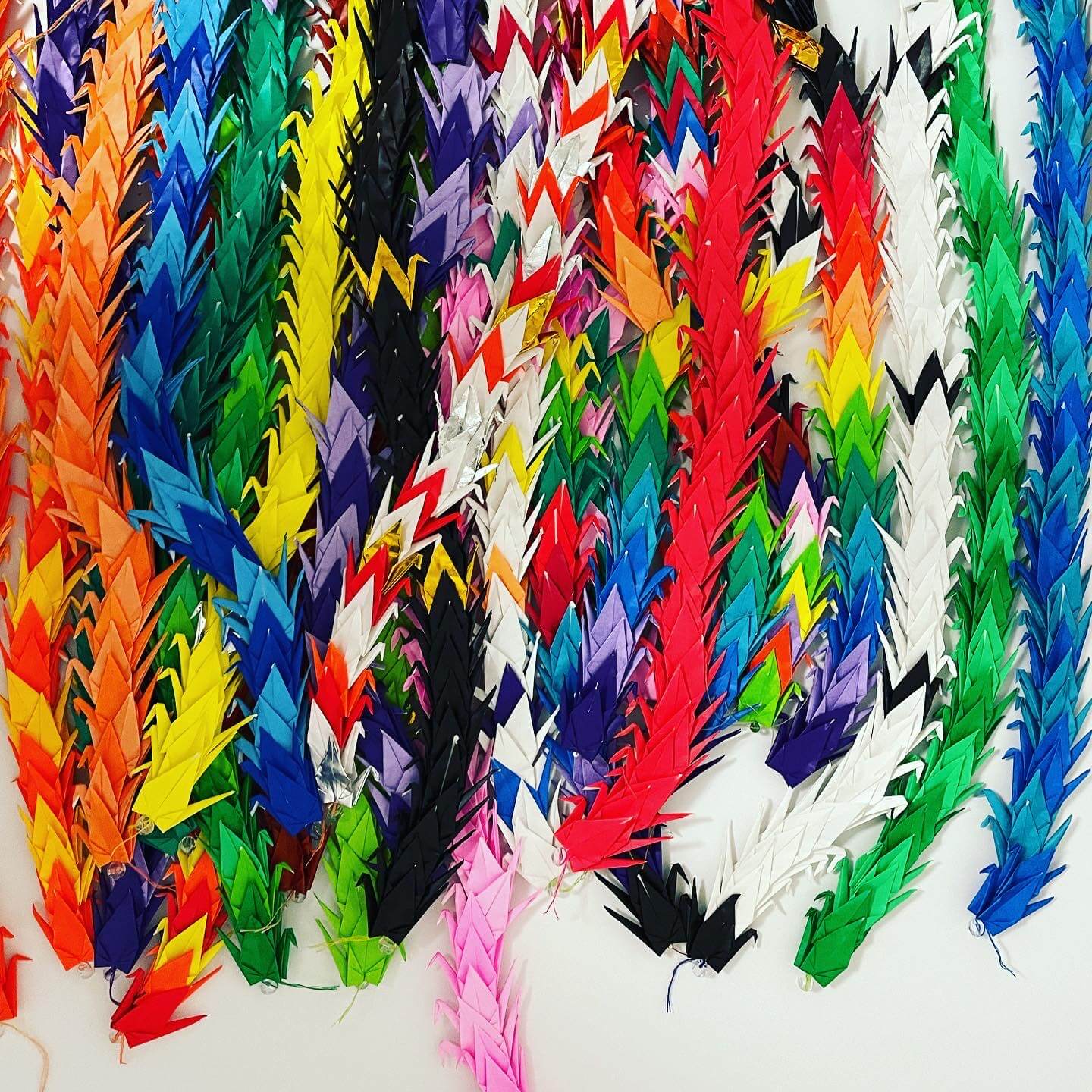 Incarceration Digital Exhibit multi colored origami cranes stringed together.